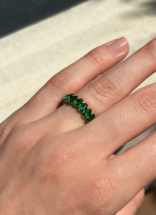 green zirconia stone ring on a hand with soft sunlight