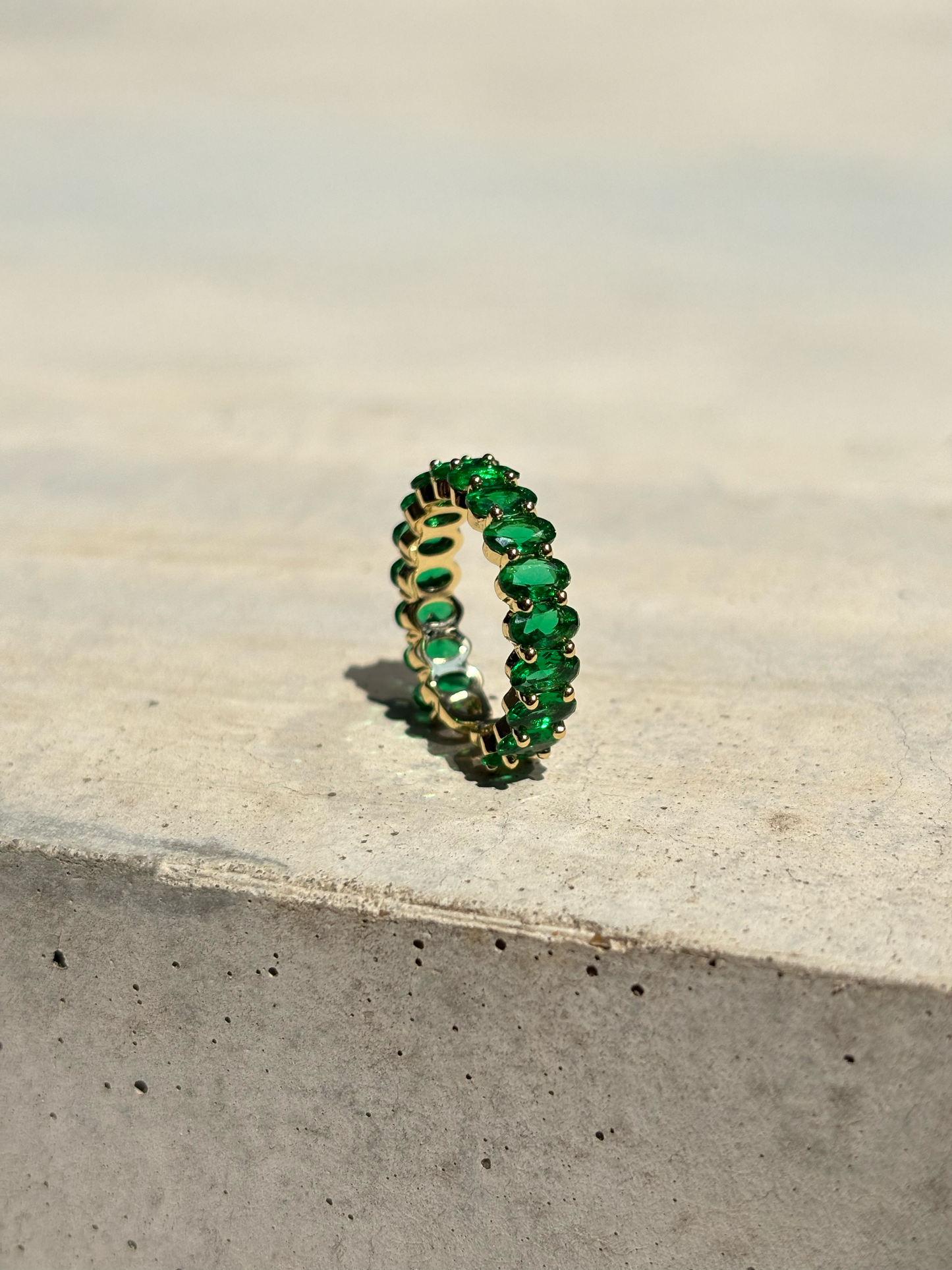 green zirconia stone ring on a concrete plate with soft sunlight