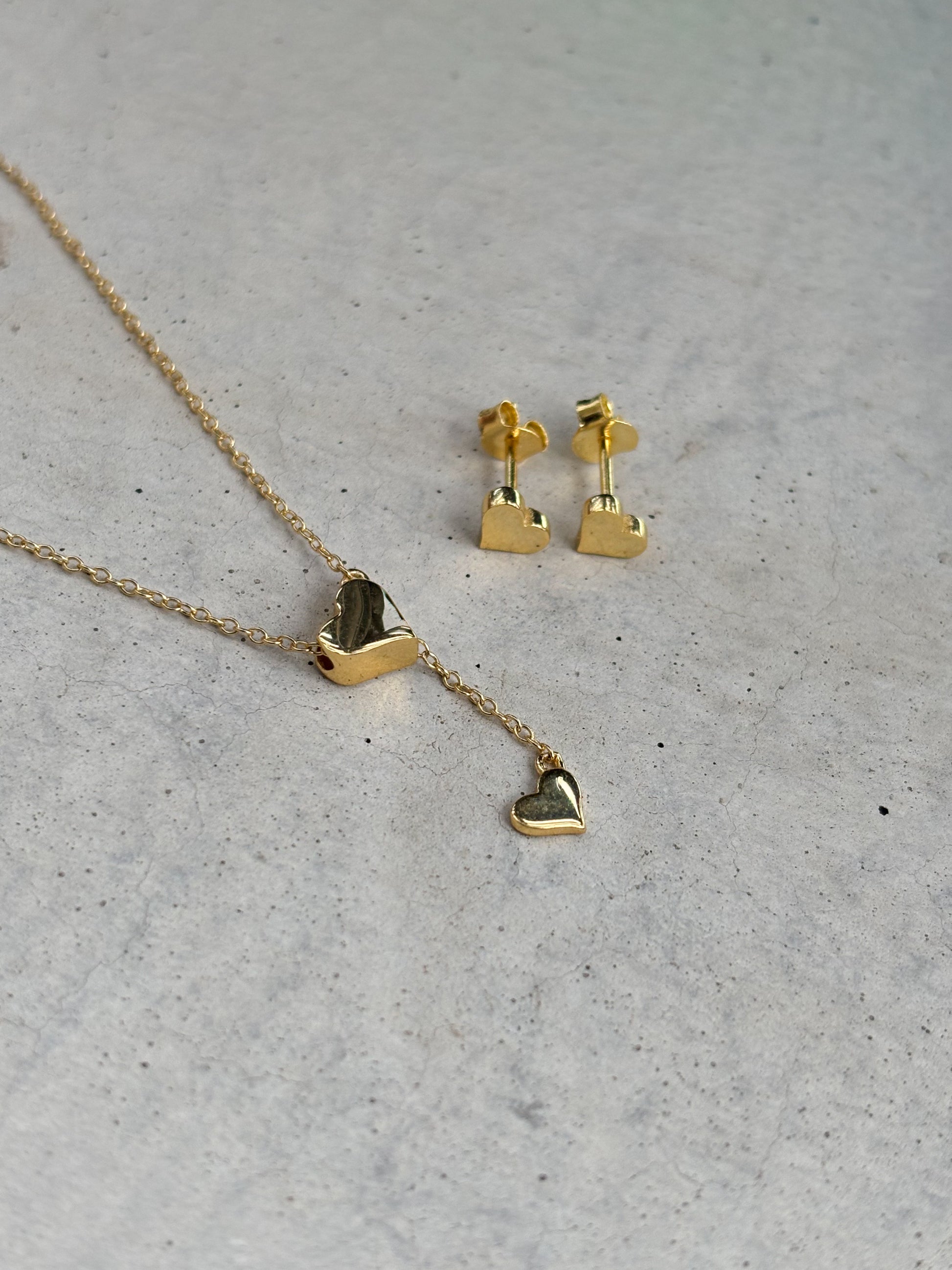golden heart-shaped necklace and heart-shaped earrings