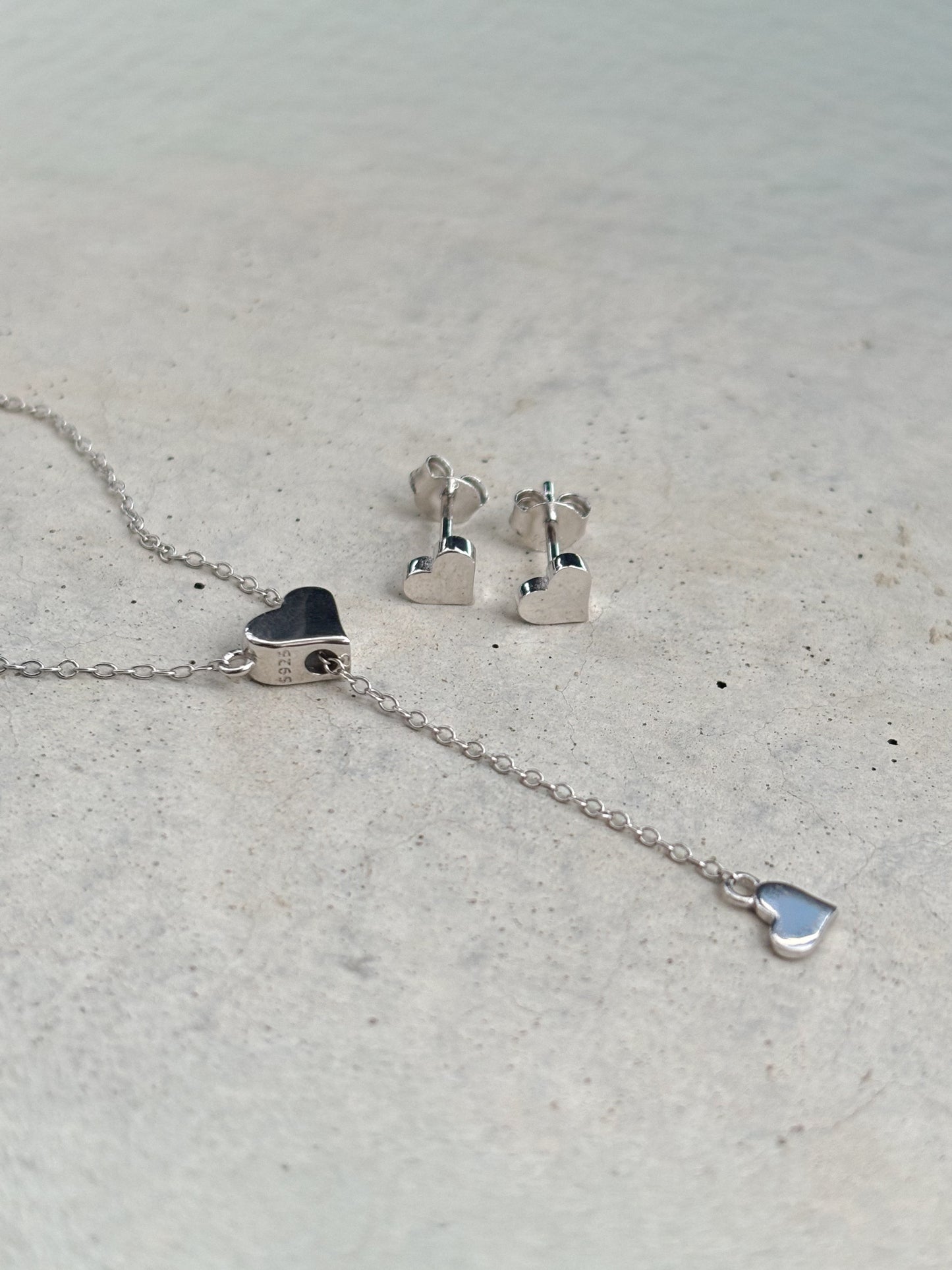 silver heart-shaped necklace and heart-shaped earrings