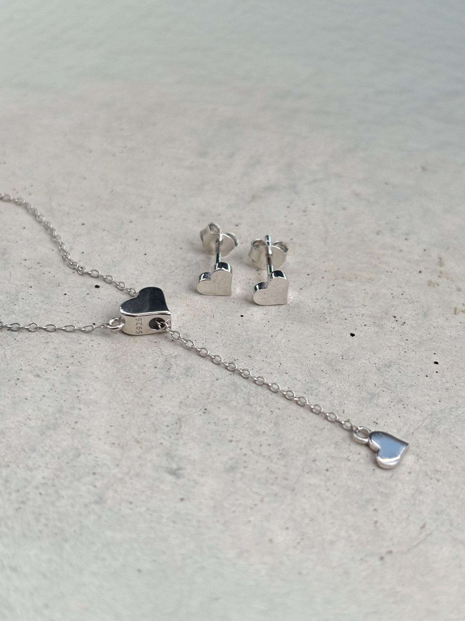 silver heart-shaped necklace and heart-shaped earrings